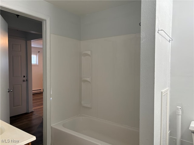 bathroom with a baseboard heating unit, vanity, wood finished floors, and shower / bathing tub combination