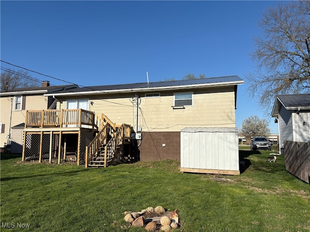 rear view of house with metal roof, a yard, stairs, and a deck
