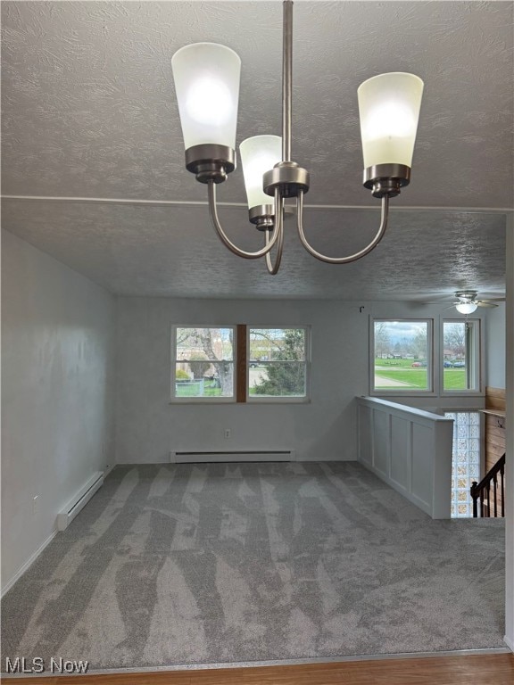 unfurnished dining area featuring carpet, a textured ceiling, a notable chandelier, and a baseboard radiator