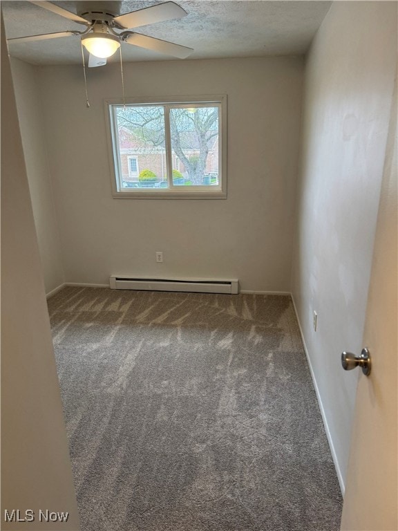 empty room featuring baseboard heating, baseboards, carpet floors, and a ceiling fan