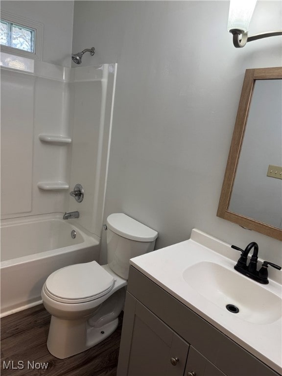 bathroom with toilet, shower / bathtub combination, vanity, and wood finished floors