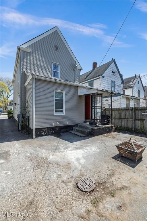 back of house featuring fence and a fire pit