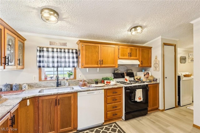 kitchen featuring light wood-style flooring, a sink, under cabinet range hood, range with gas cooktop, and dishwasher