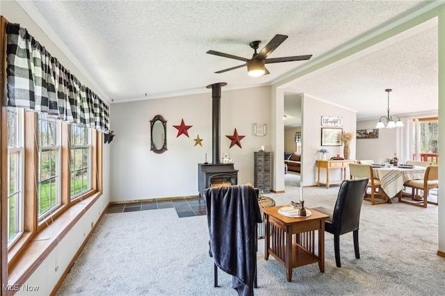 dining space featuring a wood stove, a textured ceiling, carpet flooring, and lofted ceiling