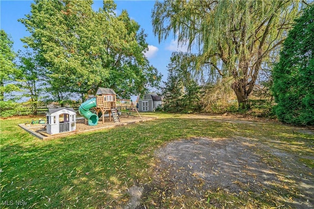 3411 Wood Rd, Madison, OH 44057 - view of green lawn with a storage unit, a playground, and an outbuilding
