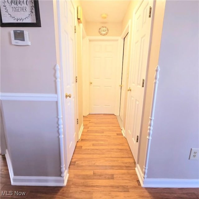 hallway with baseboards and light wood-style flooring