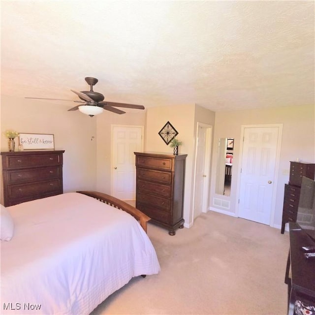 bedroom featuring light carpet and a ceiling fan