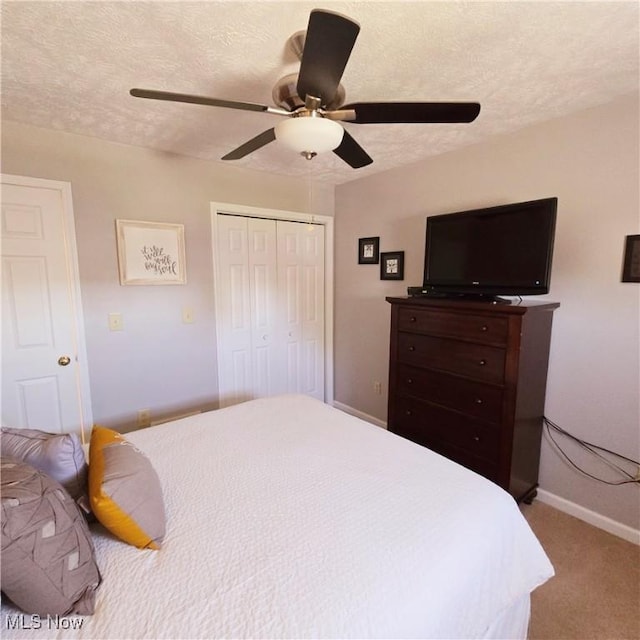 bedroom with carpet floors, a closet, baseboards, a textured ceiling, and ceiling fan