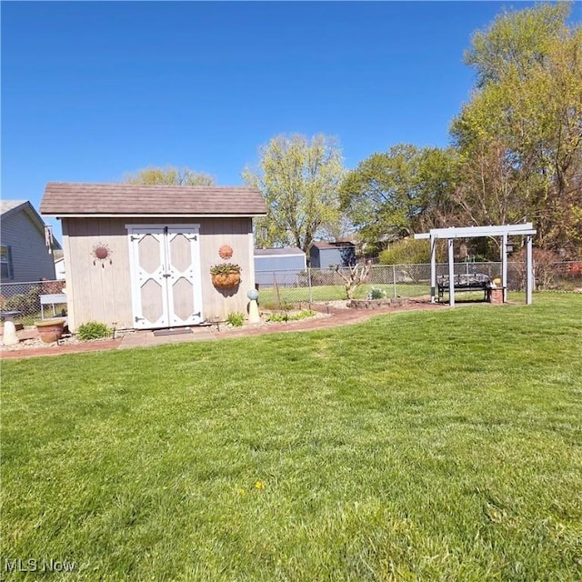 view of yard featuring fence, a pergola, an outbuilding, and a shed