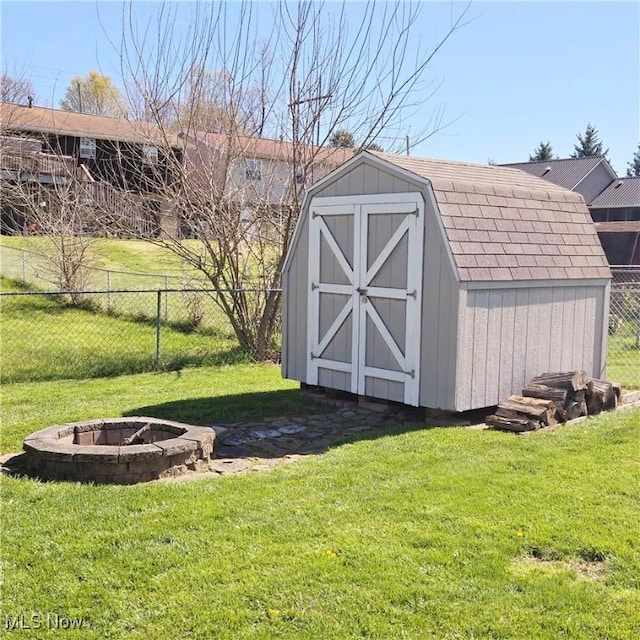 view of shed featuring fence and an outdoor fire pit