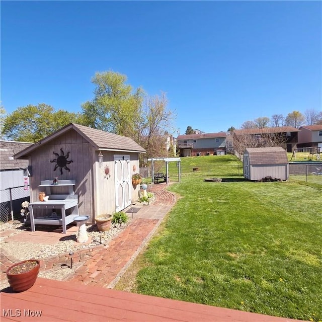 view of yard with an outdoor structure, a storage unit, and fence