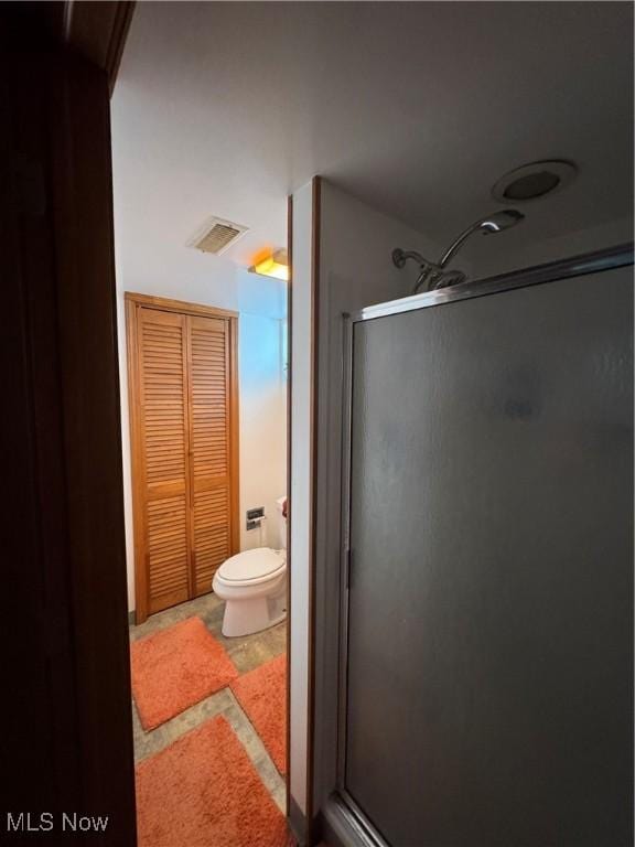 full bath with visible vents, toilet, and a stall shower