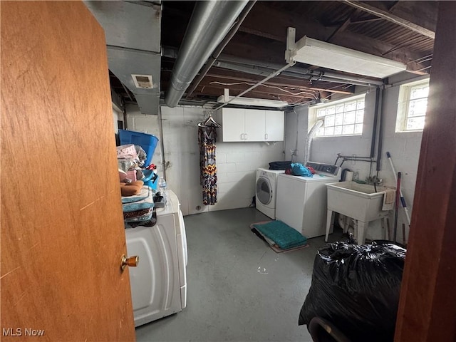 washroom with separate washer and dryer and cabinet space