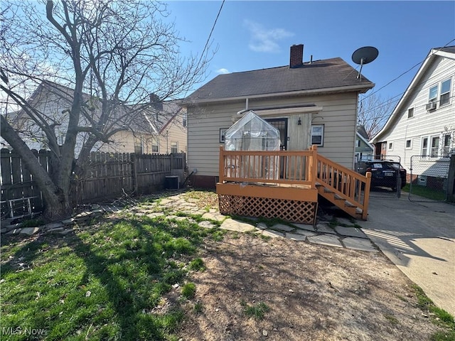 back of property featuring a chimney, central AC unit, fence, and a deck