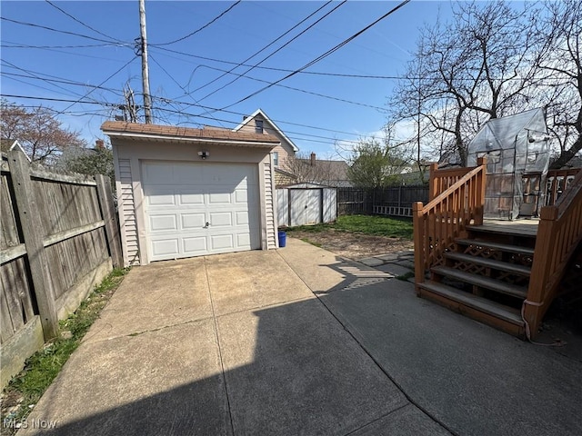 detached garage with driveway and fence