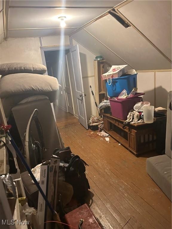 additional living space with hardwood / wood-style floors and lofted ceiling