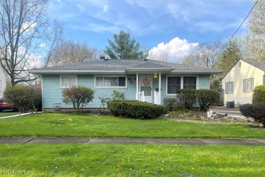 1166 Raymond St NW, Warren, OH 44485 - ranch-style house with a front yard and central AC unit