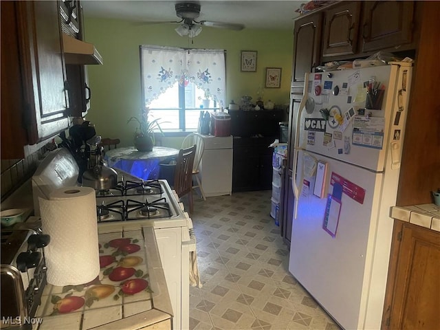 1166 Raymond St NW, Warren, OH 44485 - kitchen featuring white appliances, a ceiling fan, tile countertops, light flooring, and under cabinet range hood