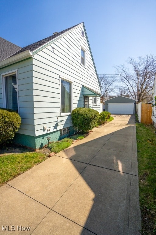 3867 E 177th St, Cleveland, OH 44128 - view of home's exterior with a detached garage, an outbuilding, and fence