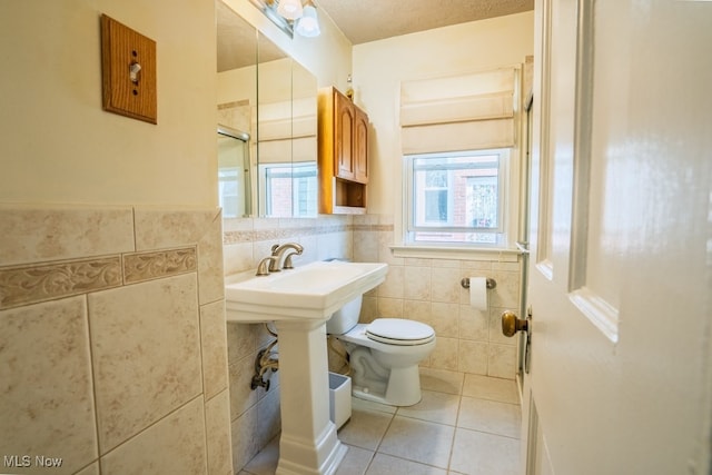 3867 E 177th St, Cleveland, OH 44128 - bathroom featuring toilet, a wainscoted wall, tile patterned floors, and tile walls