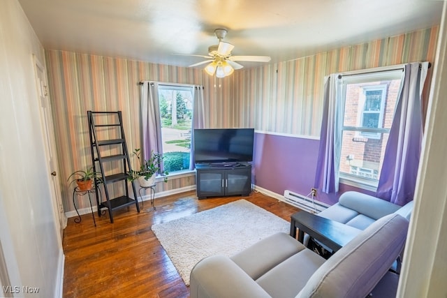 3867 E 177th St, Cleveland, OH 44128 - living room with a baseboard heating unit, wallpapered walls, wood finished floors, and baseboards