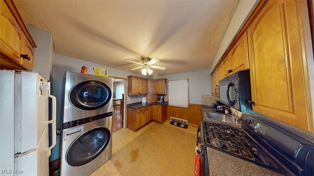 14513 Mission Rd, Cleveland, OH 44135 - laundry area featuring a sink, wainscoting, ceiling fan, stacked washer and dryer, and laundry area