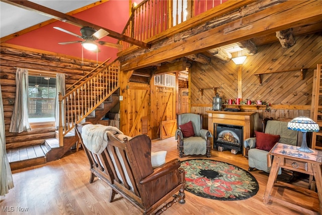 24455 Tryon Rd, Bedford, OH 44146 - sitting room with a glass covered fireplace, ceiling fan, wood finished floors, stairway, and vaulted ceiling with beams
