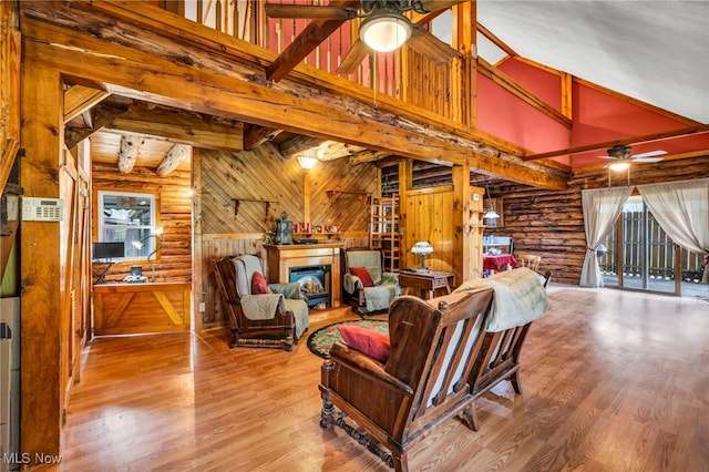 24455 Tryon Rd, Bedford, OH 44146 - living room featuring wood walls, beam ceiling, wood finished floors, ceiling fan, and a glass covered fireplace