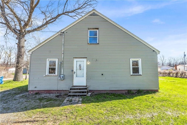 rear view of property with a yard and entry steps