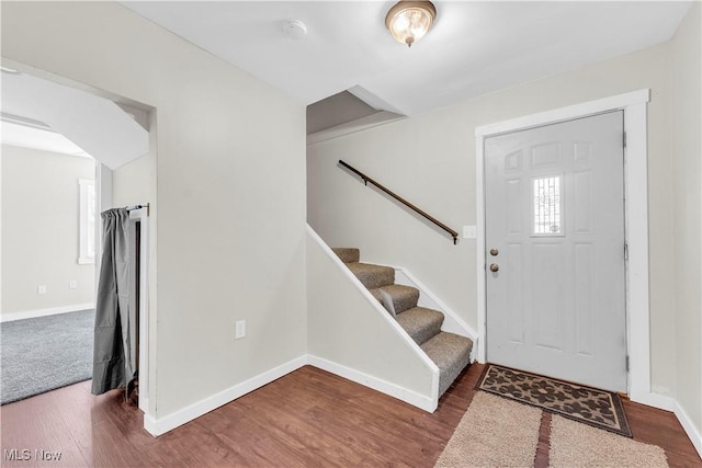 entrance foyer featuring baseboards, wood finished floors, and stairway