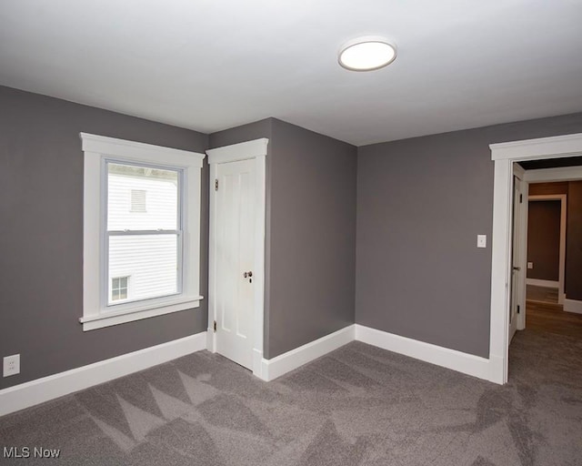 empty room featuring carpet flooring and baseboards