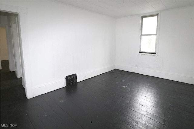 empty room featuring baseboards and dark wood-style flooring