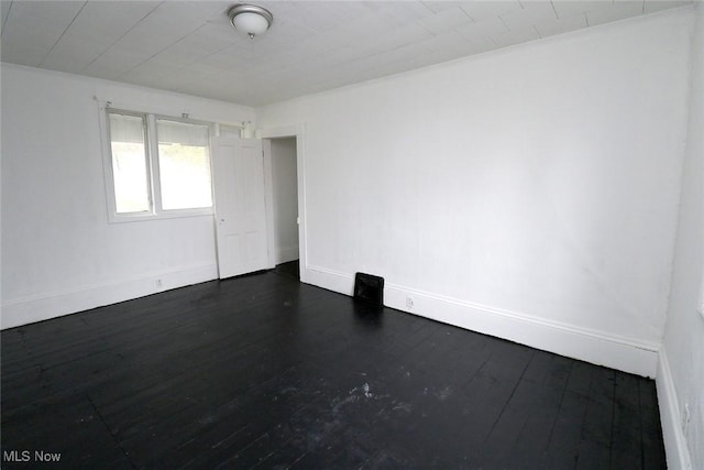 empty room with baseboards and dark wood-style floors