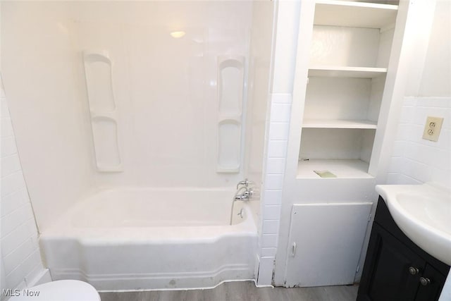 bathroom featuring vanity, wood finished floors, and tub / shower combination