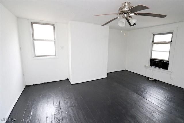 unfurnished room with cooling unit, ceiling fan, and dark wood finished floors