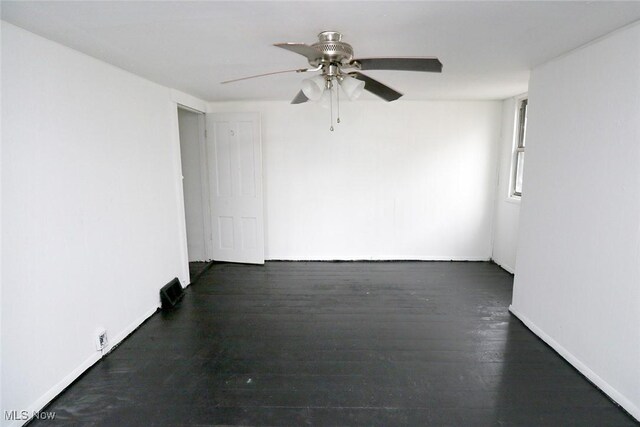 empty room with baseboards, a ceiling fan, and wood finished floors