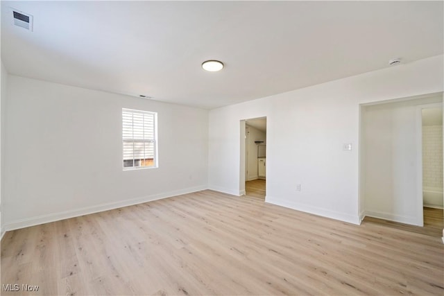 spare room featuring baseboards, visible vents, and light wood-type flooring