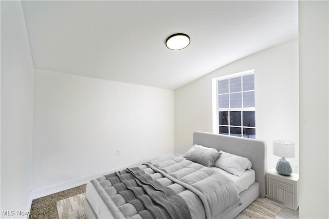 bedroom with vaulted ceiling and baseboards