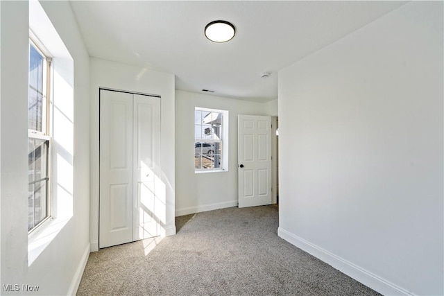 unfurnished bedroom featuring a closet, carpet flooring, baseboards, and visible vents
