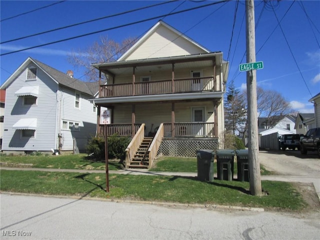 multi unit property with a porch, a front yard, and a balcony