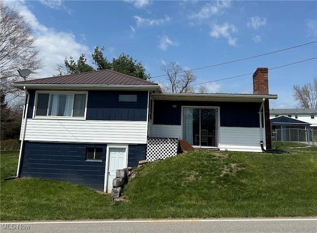 142 W Main St, Hopedale, OH 43976 - rear view of house featuring a lawn, fence, a chimney, and metal roof