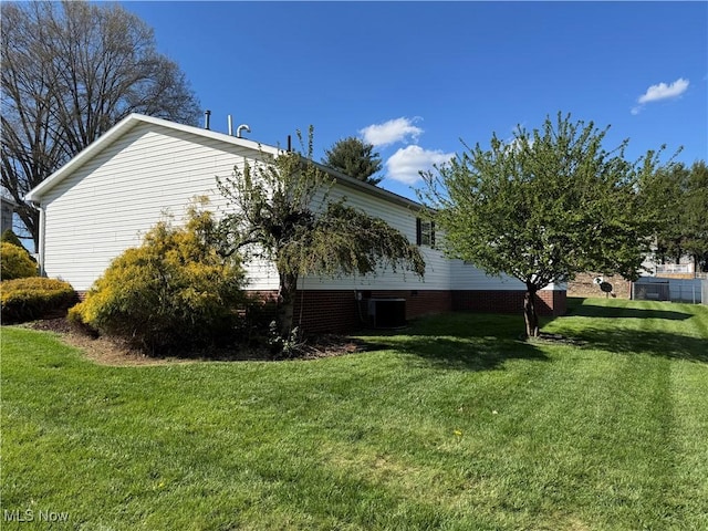 view of side of home featuring a lawn and central air condition unit