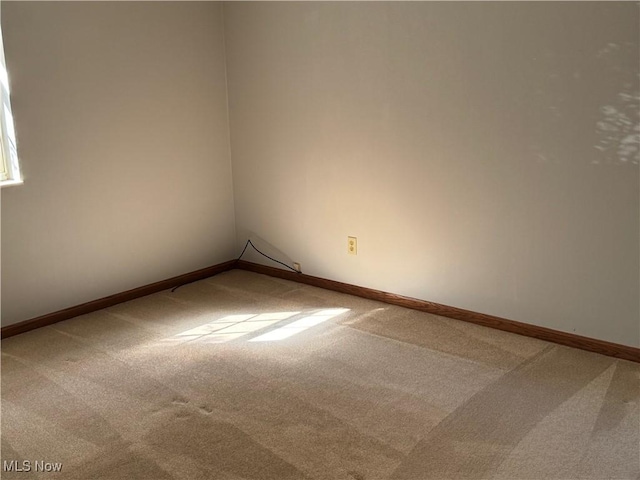 unfurnished room featuring baseboards and carpet