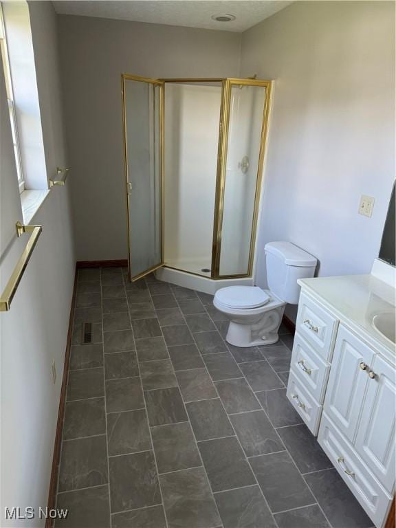 bathroom featuring vanity, tile patterned flooring, a shower stall, and toilet