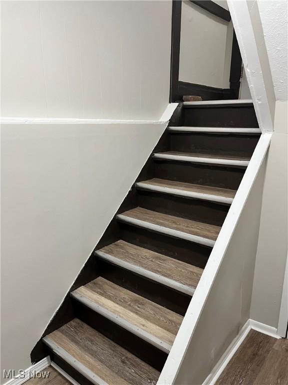 stairs featuring baseboards and wood finished floors