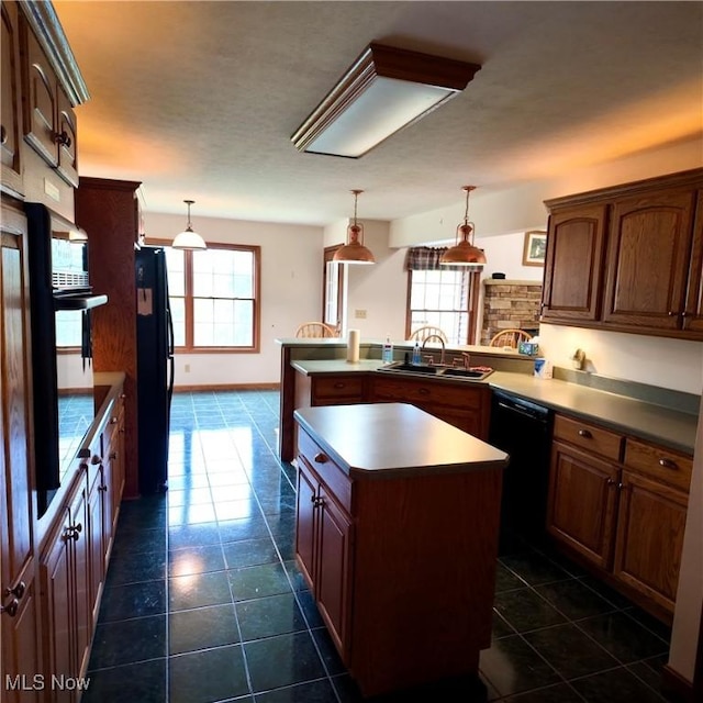 kitchen featuring a sink, dark tile patterned floors, a center island, black appliances, and a peninsula