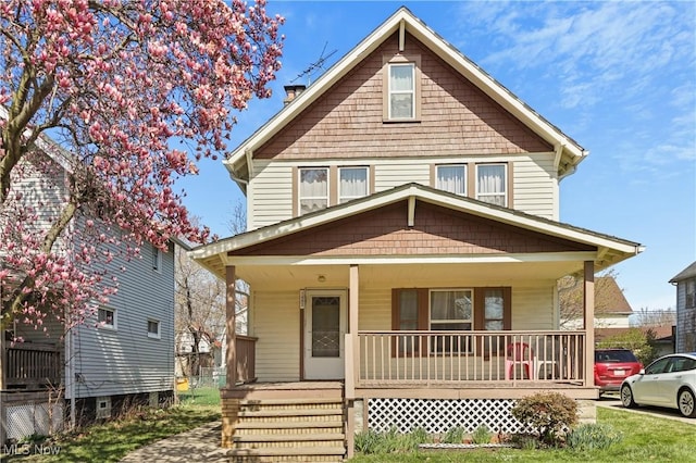 american foursquare style home featuring covered porch