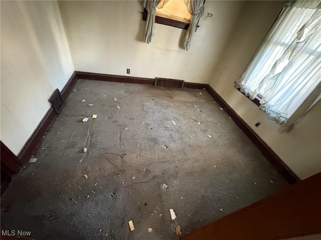 spare room with baseboards