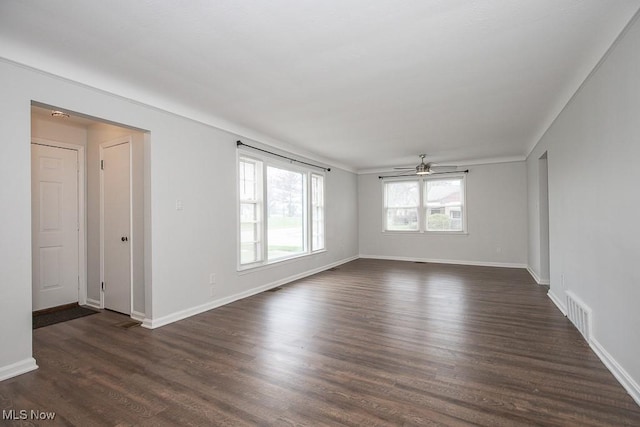 empty room with ceiling fan, baseboards, dark wood-style flooring, and visible vents