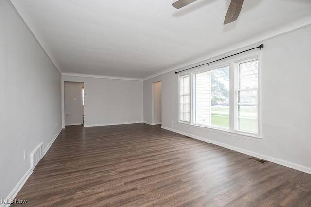 spare room with dark wood finished floors, visible vents, and a ceiling fan